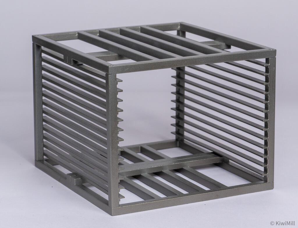 Cooking basket shown at an angle, an open metal grid cage with slotted side rails and a barred top and floor